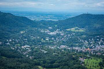 Fototapeta na wymiar Panoramalandschaft Baden-Baden, Deutschland. Blick über das Tal auf die Stadt Baden-Baden und den Schwarzwald vom Merkur an einem diesigen Sommertag.