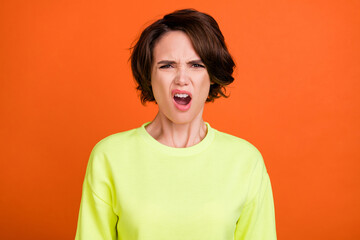 Photo of young unhappy sad displeased angry woman bad mood grimace isolated on orange color background