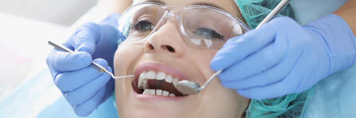 Dentist examining oral cavity of woman patient