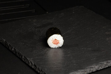 Traditional japanese nigiri sushi, separated on black stone background