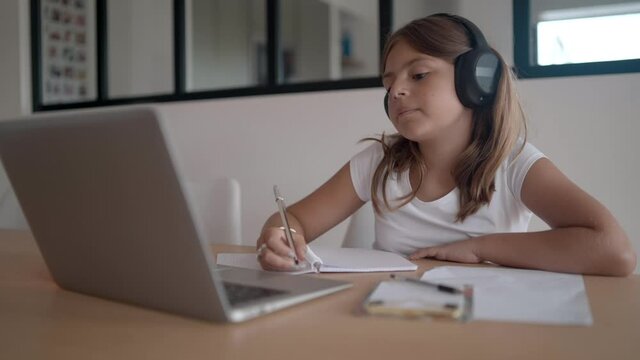 young girl on a laptop computer doing her lessons at home