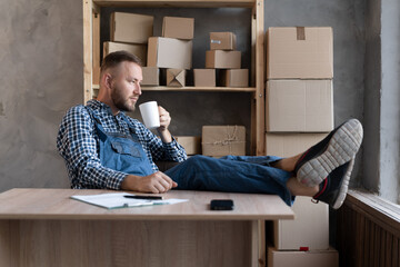 Small and medium business business concept young caucasian bearded man working and smiling at home office.