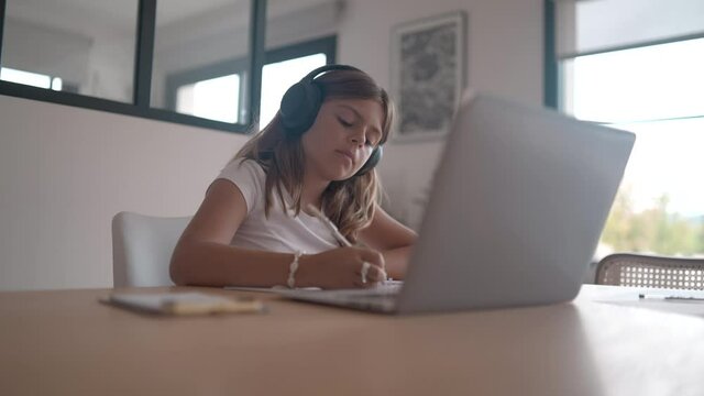 young girl on a laptop computer doing her lessons at home