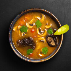 Asian soup in bowl on black background top view