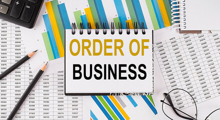 Closeup a notebook with text ORDER OF BUSINESS , business concept image on chart background