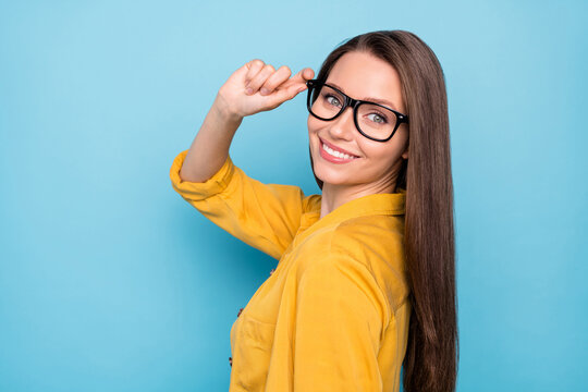 Profile side photo of young attractive pretty girl happy positive smile hand touch eyeglasses cool isolated over blue color background