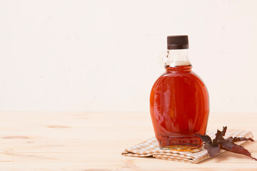 Beautiful maple syrup in a bottle. Maple leaves
