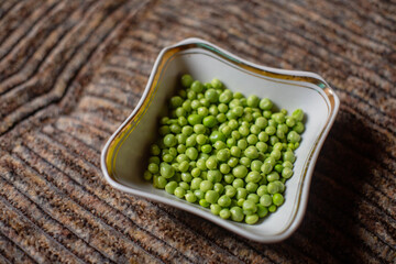 Fresh peeled green peas are in a plate