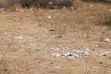 rozrzucone śmieci na polu