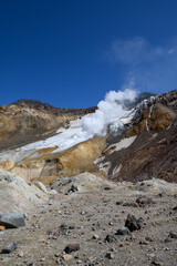 a valley of fumaroles with an eruption of water vapor and sulfur. Climbing the Mutnovsky volcano. Kamchatka Peninsula.
