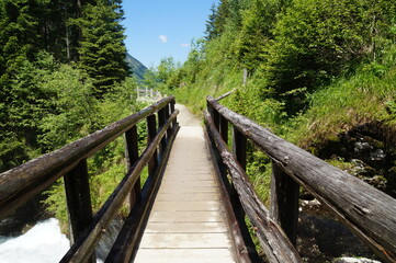 Fototapeta premium a wooden bridge over an alpine creek in the Schladming-Dachstein region in Austria