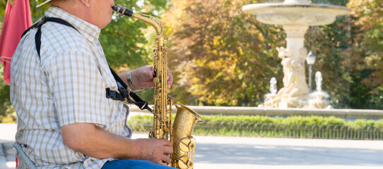 Old man playing sax alone in the park