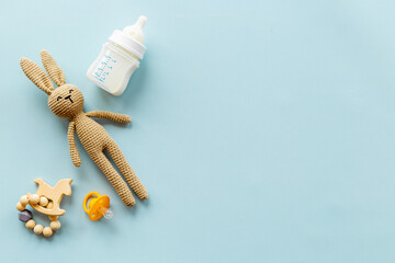 Fototapeta na wymiar Knitted baby toy bunny with milk bottle, top view