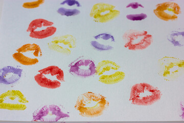 Set of multicolored female lip prints on white paper background top view. Kisses flatly. Lipstick prints, marks. Femininity, flirt, love concept. World Kissing Day. Valentine's Day. Lovely backdrop.