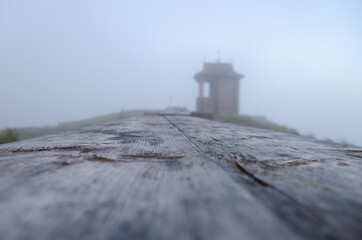 wooden chapel  in fog on the top of the mountain 