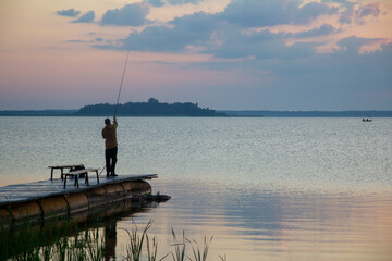 Morning fishing. A fisherman throws a fishing rod into the water.