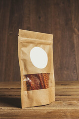 delicious jerky on a wooden background. products in craft packaging. snack for alcohol. macro...