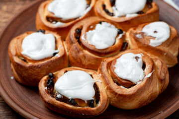 Buttery sweet buns with raisins. Covered with white sugar syrup.