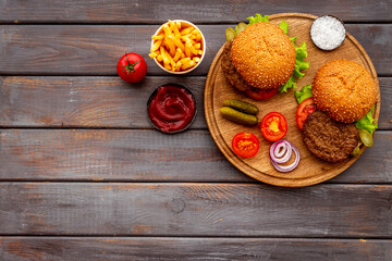 Hamburgers with vegetales and french fries. Top view