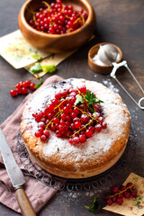Tasty homemade pie with red currant and fresh red currants on dark grey rustic background. Summer pie or baking.