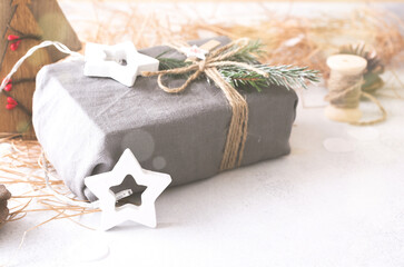 Decorative wooden Christmas tree and star, cone and fabric wrapped gifts, on a light background. Zero waste concept