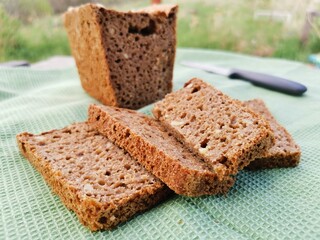 Fototapeta na wymiar sliced rye homemade bread square shape on a green towel