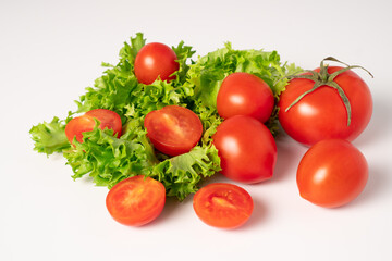 Perfect tomatoes with lettuce. Fresh salad on white table. Small-sized tomatoes