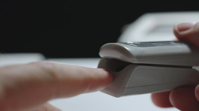 Oximeter. Man using digital device to monitor an oxygen level. Closeup.