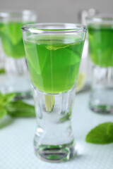 Fototapeta na wymiar Delicious mint liqueur with lime on table, closeup