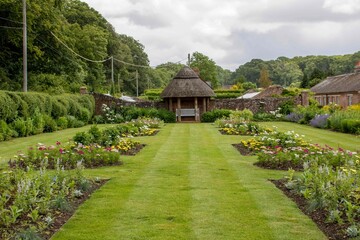 picturesque thatched gazebo in a beautiful english garden