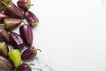 Sweet peppers for salad on a light background. Vegetables for the salad. Natural light. Purple, green peppers.
