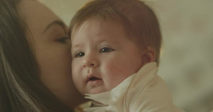 Mother and her Newborn Baby . Happy Mother holding new born baby .  Baby girl kissing and hugging . Maternity concept. Parenthood Motherhood. Beautiful Happy Family . Shot on RED camera in Slow Motion