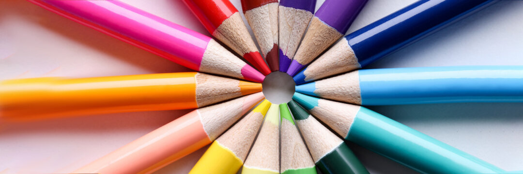Multicolored pencils lying in shape of sun closeup