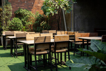 Stylish wooden table and chairs empty on background of brick wall in restaurant.