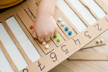 Insert a suitable strap with cotton balls into the designated cavity with the number. Pre-school education assistance for kindergartens. children learn the Montessori IQ early. Math task for baby.