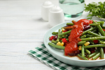Delicious salad with green beans and tomato sauce served on white wooden table, closeup. Space for text