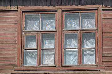 Two windows of an old wooden house close-up