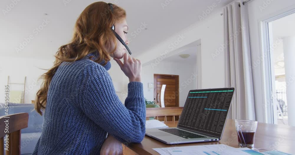 Canvas Prints Caucasian woman sitting at desk coding data on laptop