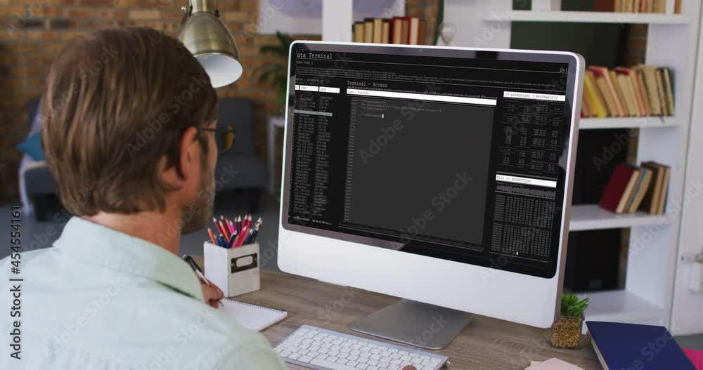 Poster caucasian man sitting at desk watching coding data processing on computer screen
