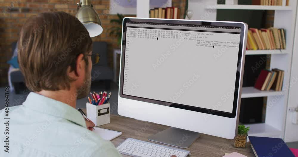 Poster Caucasian man sitting at desk watching coding data processing on computer screen