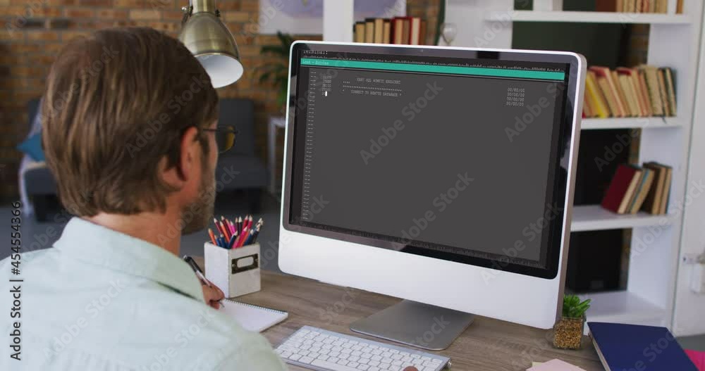 Poster caucasian man sitting at desk watching coding data processing on computer screen