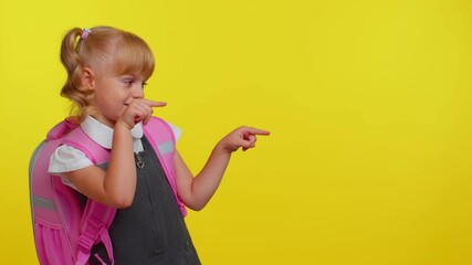 Attractive blond teenage girl kid in school uniform wears pink backpack showing thumbs up and pointing right at copy-space for promotional content on yellow studio background. Education back to school - Powered by Adobe