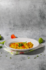 Vegetarian Noodles plate with coriander, green chili and tomatoes on grey background.  with copy space.