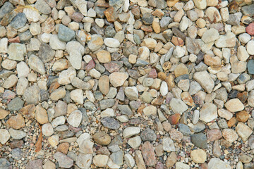 Natural colorful pebble stones background texture with copy space.