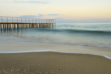 Tranquil relaxing seascape. old rusty pier and sea. Long exposure, washed out water.