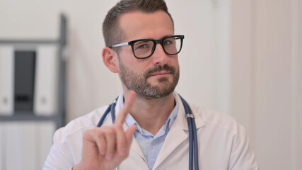 Portrait of Middle Aged Doctor showing No Sign with Finger 
