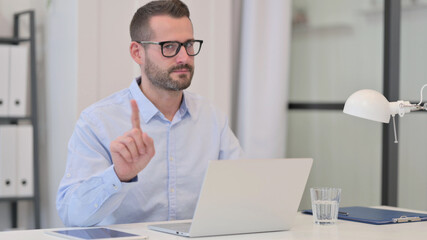 Middle Aged Man with Laptop showing No Sign by Finger