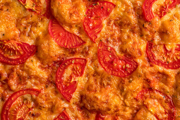 Closeup on baked margherita pizza texture with cheese and tomatoes