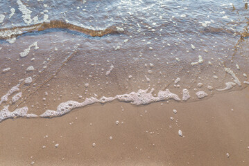 Soft wave of the sea on the sandy evening beach.Soft focus,blurred image.