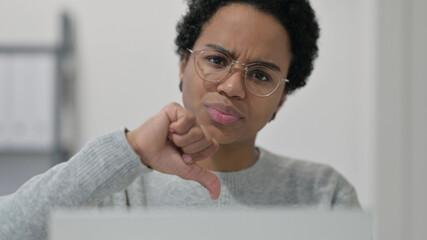 Thumbs Down by African Woman using Laptop 